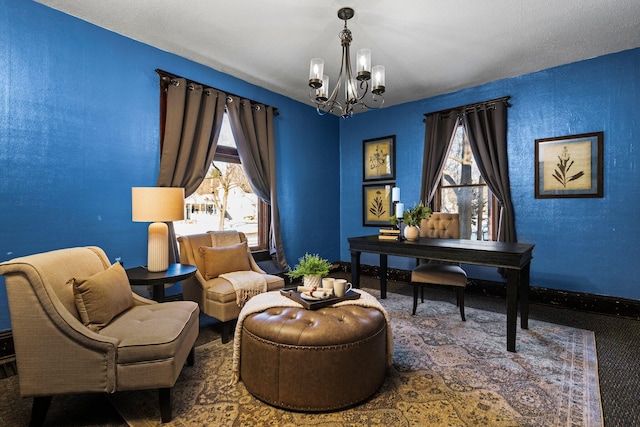 sitting room featuring baseboards and a notable chandelier