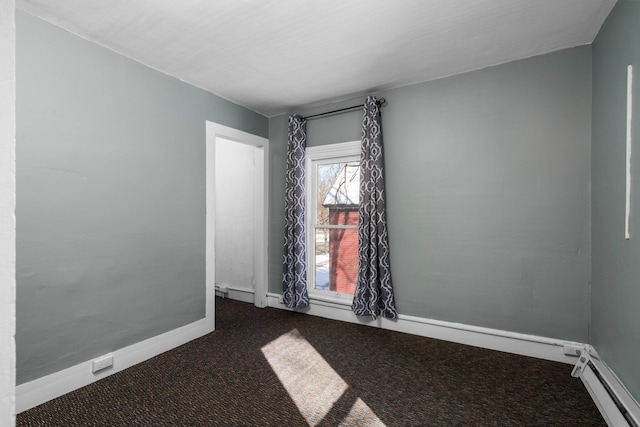 empty room with carpet floors, a baseboard radiator, and baseboards