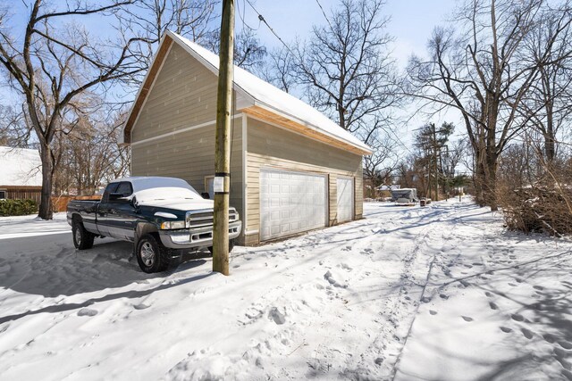 snow covered garage with a garage