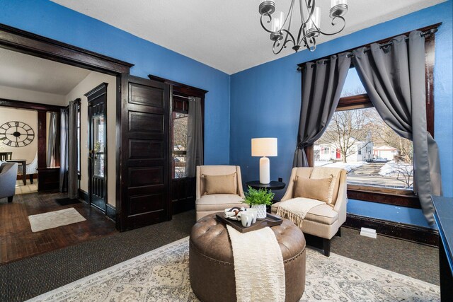 sitting room featuring a chandelier, a healthy amount of sunlight, and baseboards