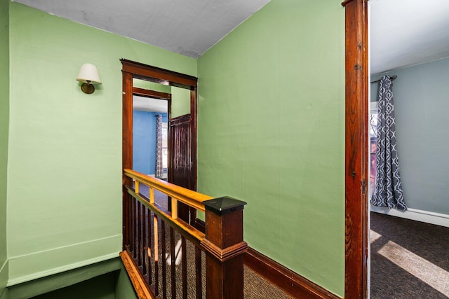 hallway featuring carpet and an upstairs landing