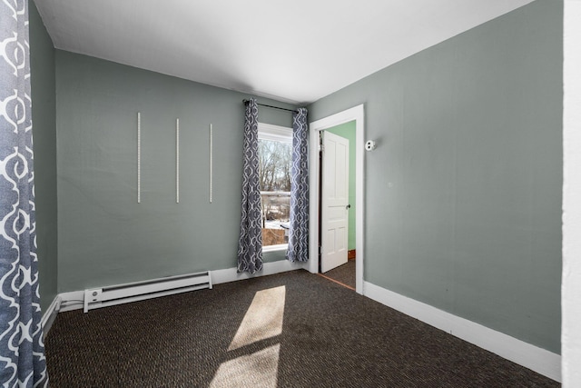 spare room with baseboards, a baseboard heating unit, and dark colored carpet