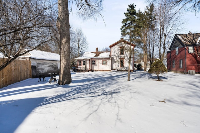 yard layered in snow featuring fence and cooling unit