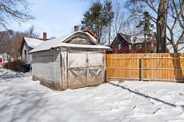 snow covered structure featuring fence