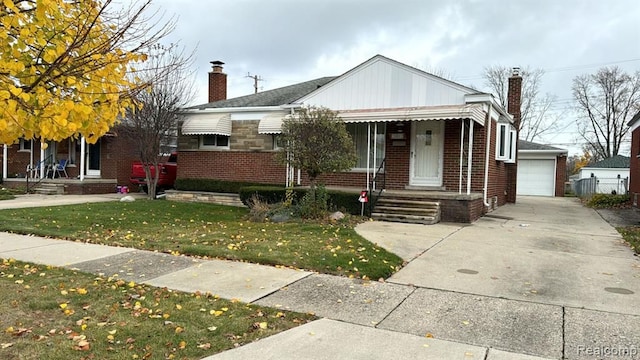 bungalow with brick siding, a chimney, a front yard, and an outdoor structure