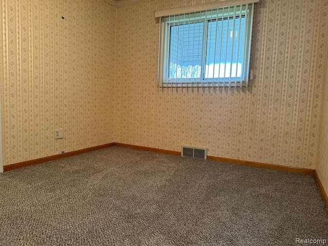 carpeted empty room with baseboards, visible vents, and wallpapered walls