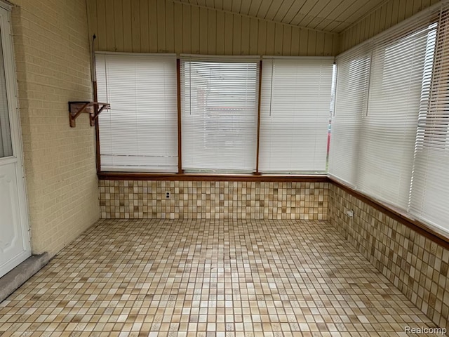 unfurnished sunroom with vaulted ceiling