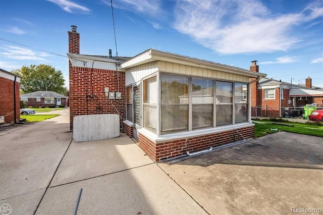 view of side of property featuring a patio and brick siding