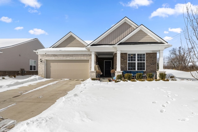 craftsman house with a garage, brick siding, and board and batten siding