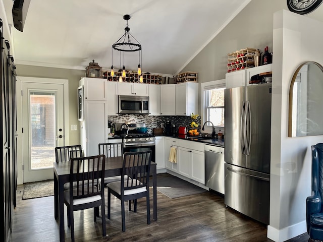 21865 Novi Rd, Northville, MI 48167 - kitchen with appliances with stainless steel finishes, dark countertops, decorative backsplash, white cabinetry, and lofted ceiling
