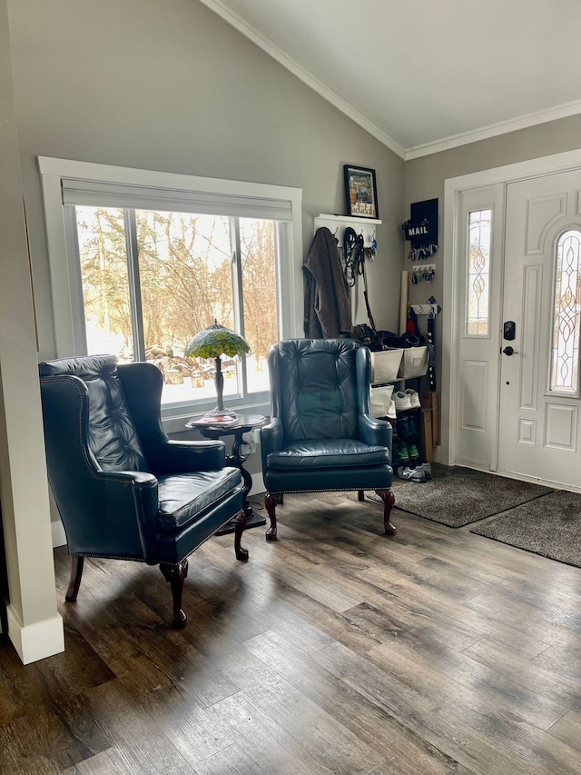 entryway featuring ornamental molding, vaulted ceiling, and wood finished floors