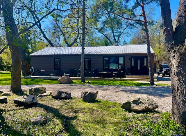 21865 Novi Rd, Northville, MI 48167 - rear view of property with a metal roof and a yard