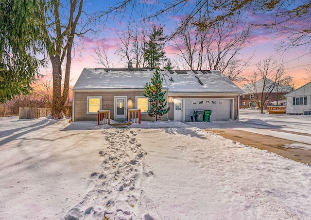 view of front of home with driveway, an attached garage, and fence