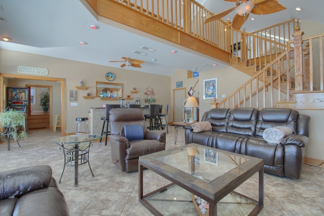 living area featuring recessed lighting, stairway, a towering ceiling, a ceiling fan, and baseboards