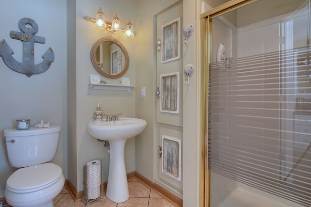 bathroom with baseboards, a shower stall, toilet, and tile patterned floors