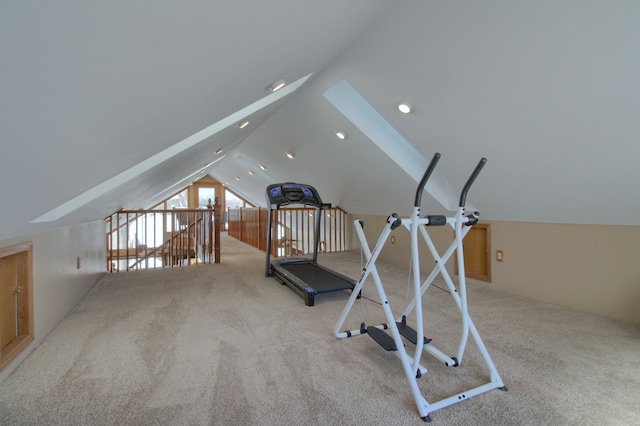 exercise area featuring light carpet and lofted ceiling with skylight