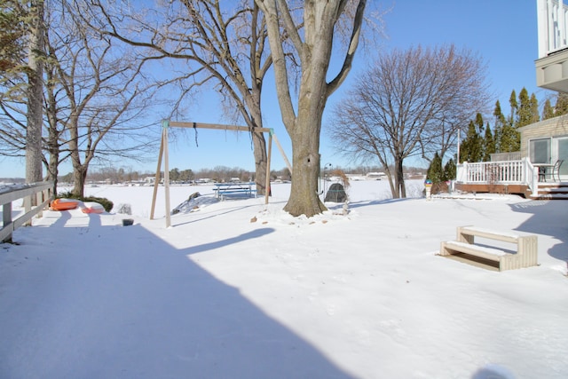 yard covered in snow with a deck