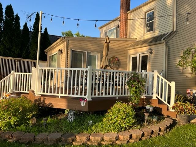 back of house featuring a deck and a chimney