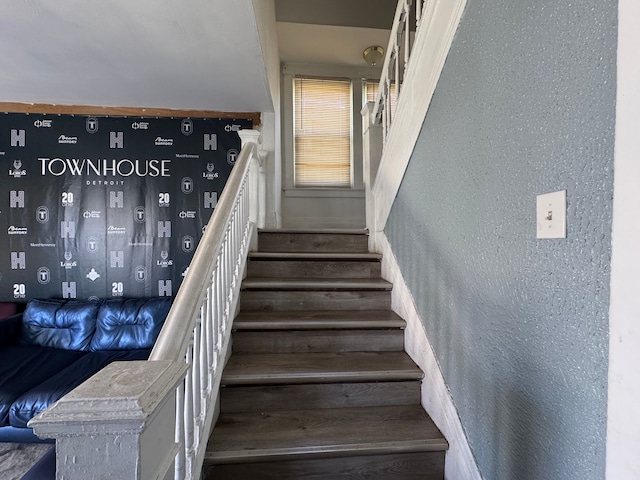 stairway featuring a textured wall