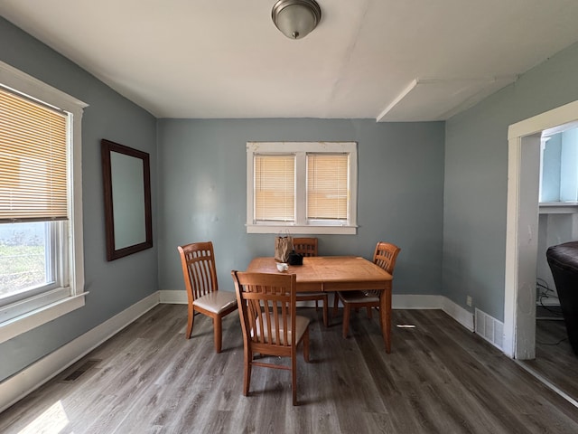 dining room featuring baseboards, wood finished floors, and visible vents