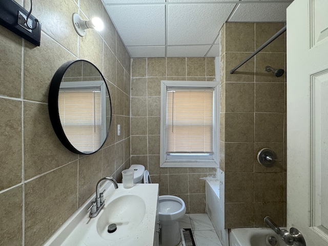 bathroom with shower / bath combination, tile walls, toilet, and vanity