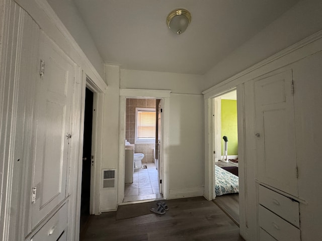 hallway featuring baseboards and dark wood finished floors
