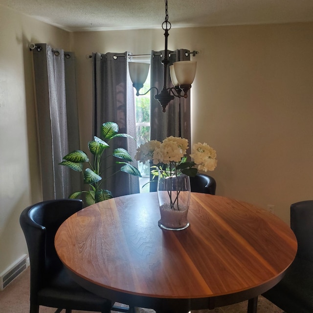 dining area with visible vents and a textured ceiling