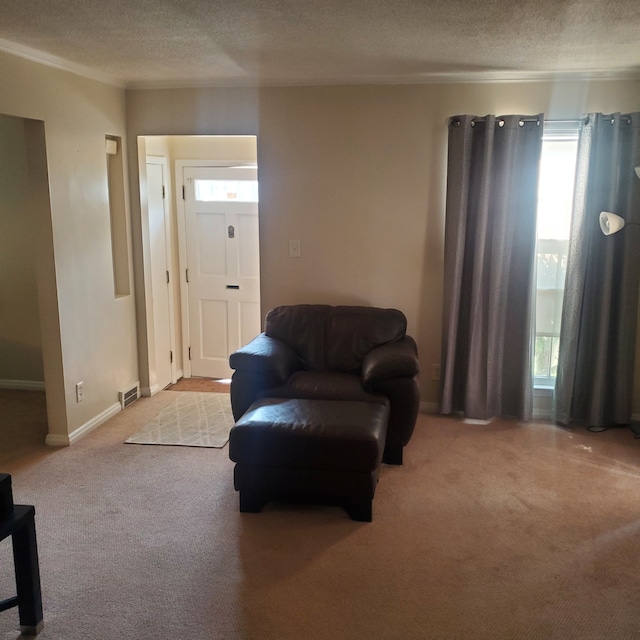 living area with visible vents, light colored carpet, a textured ceiling, and baseboards