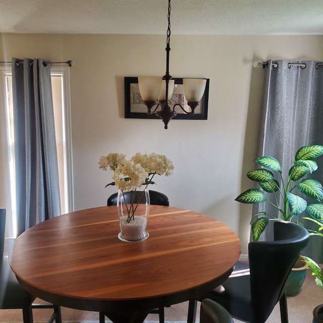 dining area with an inviting chandelier and a textured ceiling