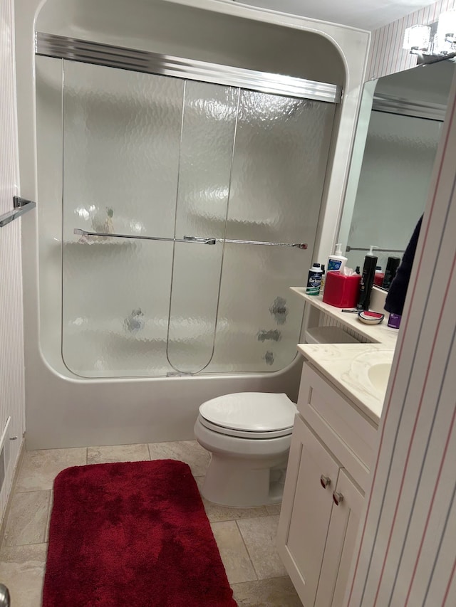 full bathroom with combined bath / shower with glass door, vanity, and toilet