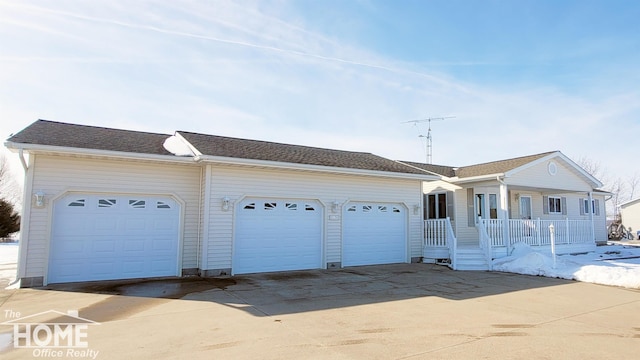 single story home featuring covered porch, driveway, and an attached garage