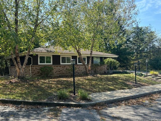 single story home with brick siding and fence