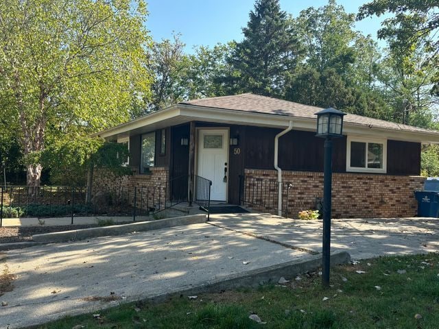 single story home with driveway and brick siding