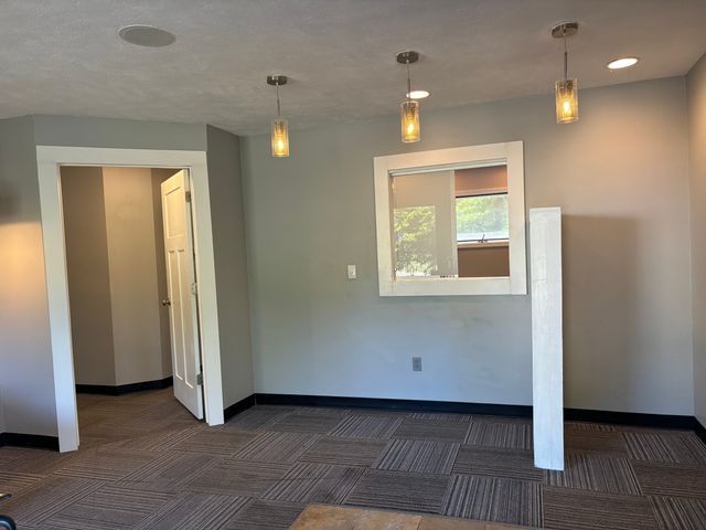 empty room with dark colored carpet and baseboards