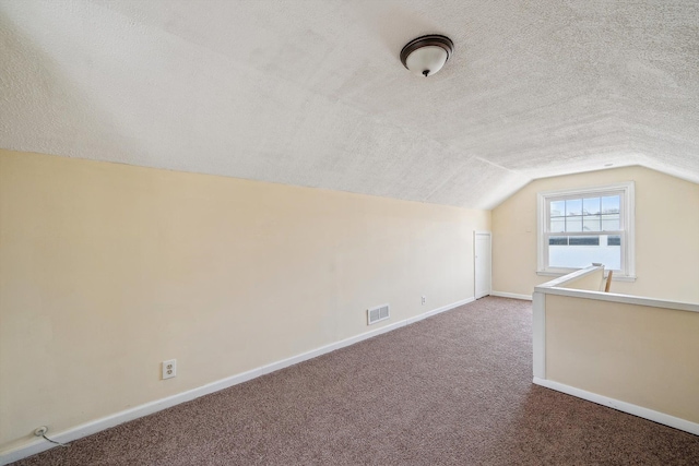 bonus room featuring a textured ceiling, lofted ceiling, visible vents, and baseboards