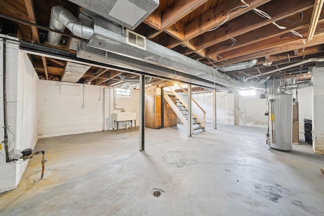 basement featuring a sink, stairs, visible vents, and gas water heater