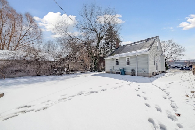 view of snow covered back of property