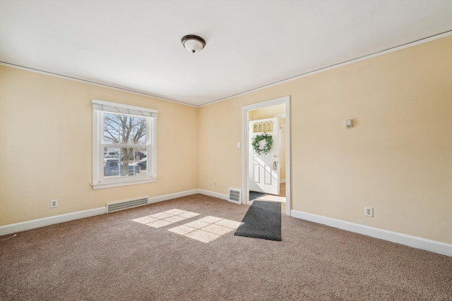 foyer entrance featuring light carpet, visible vents, and baseboards