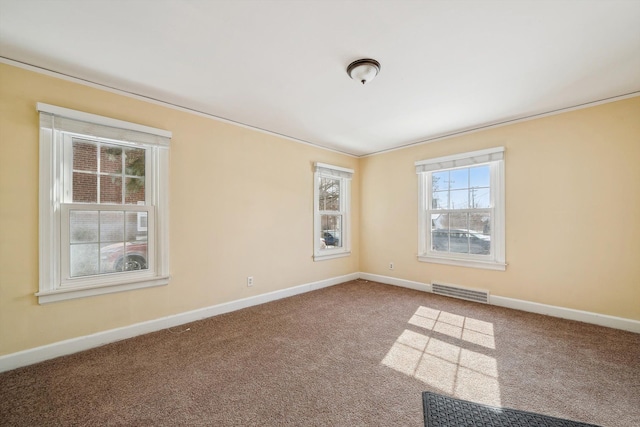 carpeted spare room with baseboards and visible vents