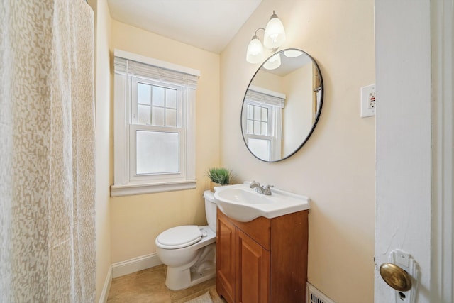 bathroom with baseboards, vanity, and toilet