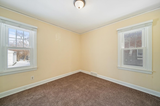 empty room with baseboards, visible vents, and carpet flooring