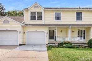 view of front of property with covered porch, a front lawn, and concrete driveway