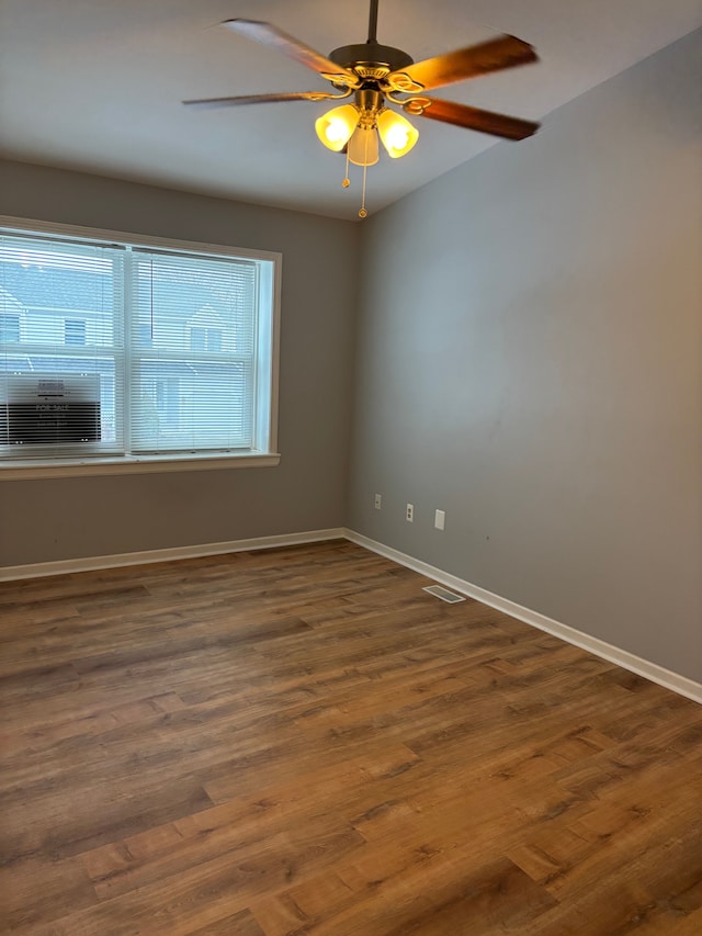 spare room featuring a ceiling fan, baseboards, and wood finished floors