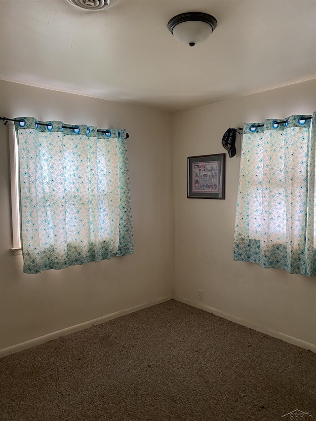 carpeted spare room with baseboards