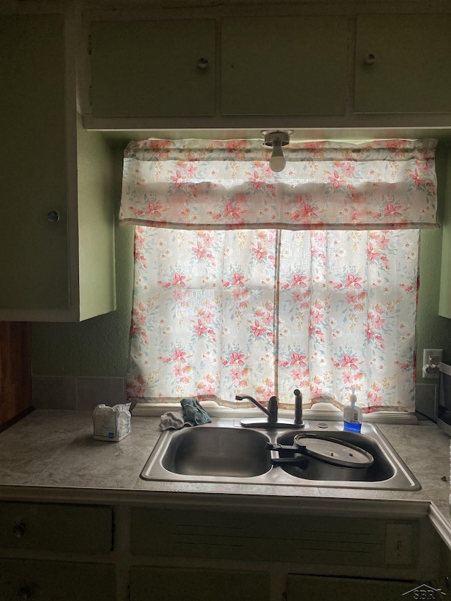 kitchen featuring green cabinetry and a sink