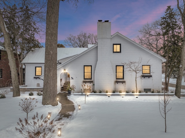 snow covered property with a chimney