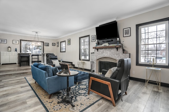 living area featuring ornamental molding, a wealth of natural light, light wood-style flooring, and baseboards