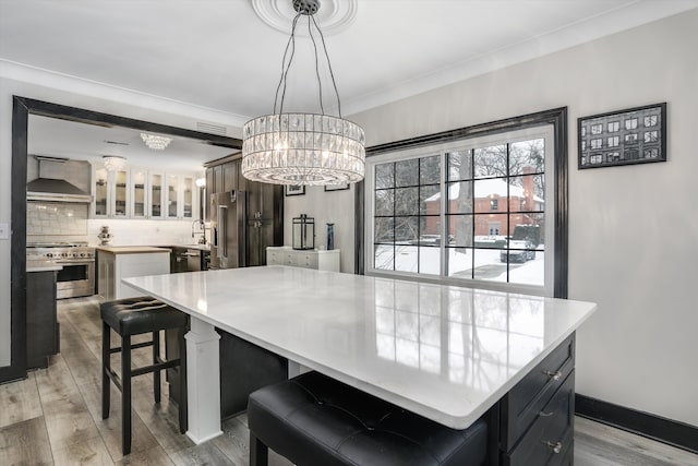 dining area featuring light wood finished floors, visible vents, baseboards, and crown molding