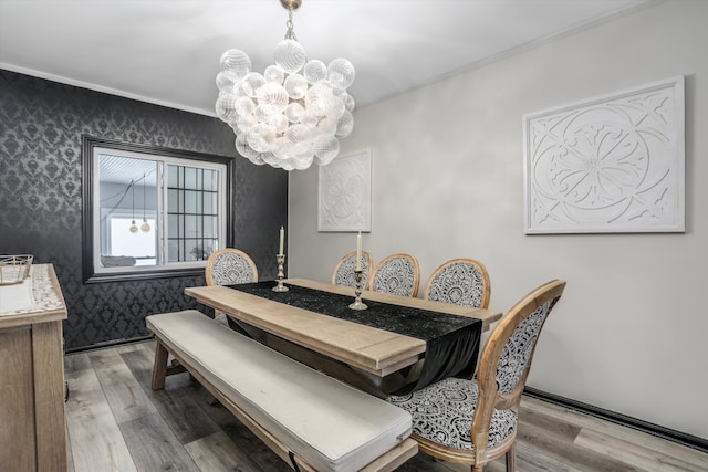 dining space featuring wallpapered walls, light wood finished floors, and a notable chandelier