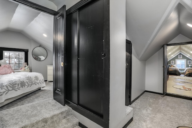 bedroom featuring baseboards, vaulted ceiling, a closet, and light colored carpet